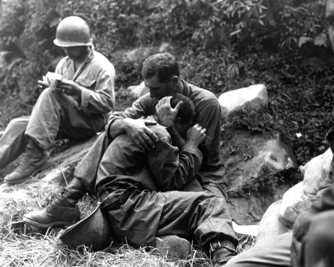 A grief stricken American infantryman whose buddy has been killed in action is comforted by another soldier. In the background a corpsman methodically fills out casualty tags, Haktong-ni area, Korea.  August 28, 1950.  Sfc. Al Chang. (Army)
NARA FILE #  080-SC-347803
WAR & CONFLICT BOOK #:  1459