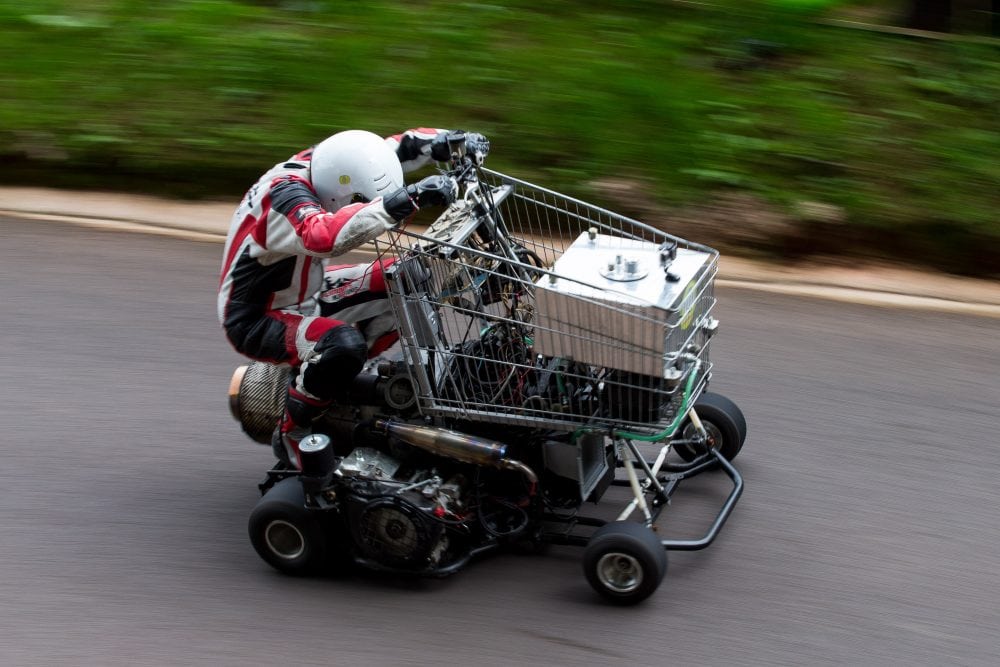 Matt Mckeown 55 drives the uphill course in his converted shopping trolley. Shelsley Walsh Hill Climb, Shelsley Walsh, Worcestershire. September 04, 2016.  This is the bizarre moment a petrol head competed in a motorcycle road race - in a jet-powered SHOPPING TROLLEY. See NTI story NTITROLLEY.  Madcap Matt McKeown, 55, of Plymouth, Devon, build his wacky racer - which has a top speed of 80mph - from an abandoned cart he found in a ditch.  He bolted on brakes, go-kart wheels and a 150 horsepower engine from a Chinook helicopter before taking it for time trials.  Matt first set a record of 45.5mph then made several tweaks and broke his own record by reaching 71.4mph at Elvington Airfield in North Yorks.  On Sunday (4/9) Matt wowed the crowds when he competed in the Shelsley Walsh Hill climb in Worcestershire.  Despite crawling up the 1,000 yard course - which hits a steep 1:7 incline at its peak - Matt wasn't last to finish and managed to beat a number of other conventional bikes.
