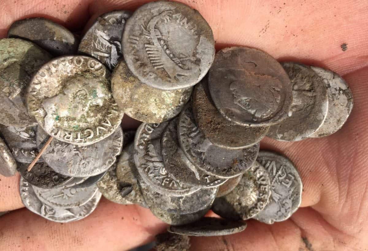 Hundreds of Roman denarii have been found by Historian Mike Scale during a metal detectors event in Bridport, Dorset. See SWNS story SWDETECT; An amateur historian digging in a farmer's field has told how he found a once in a lifetime hoard of 2000-year-old Roman silver coins - worth up to £200,000. Mike Smale, 35, found the hoard of 600 rare denarii in a farmer's field in Bridport while hunting with his pals from the Southern Detectorists club. A single one can sell for up to £900 so the fisherman was astonished when he uncovered nugget after nugget of pristine coins dating back to 32BC. Some of the metal disks were minted by Mark Antony while he was allied with his lover Cleopatra in Egypt and experts said a find of this size and variety is very rare. The coins will be handed over to the coroner for valuation and then likely sold to a museum, with the profits split between the farmer and Mike. Dad-of-one Mike, a fisherman from Plymouth, Devon, said: "It was incredible, a true once-in-a-lifetime find.