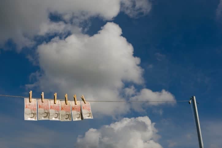 UK currency - new £50 notes - 'drying' on a washing line on a Summer's day. Symbolising money laundering.