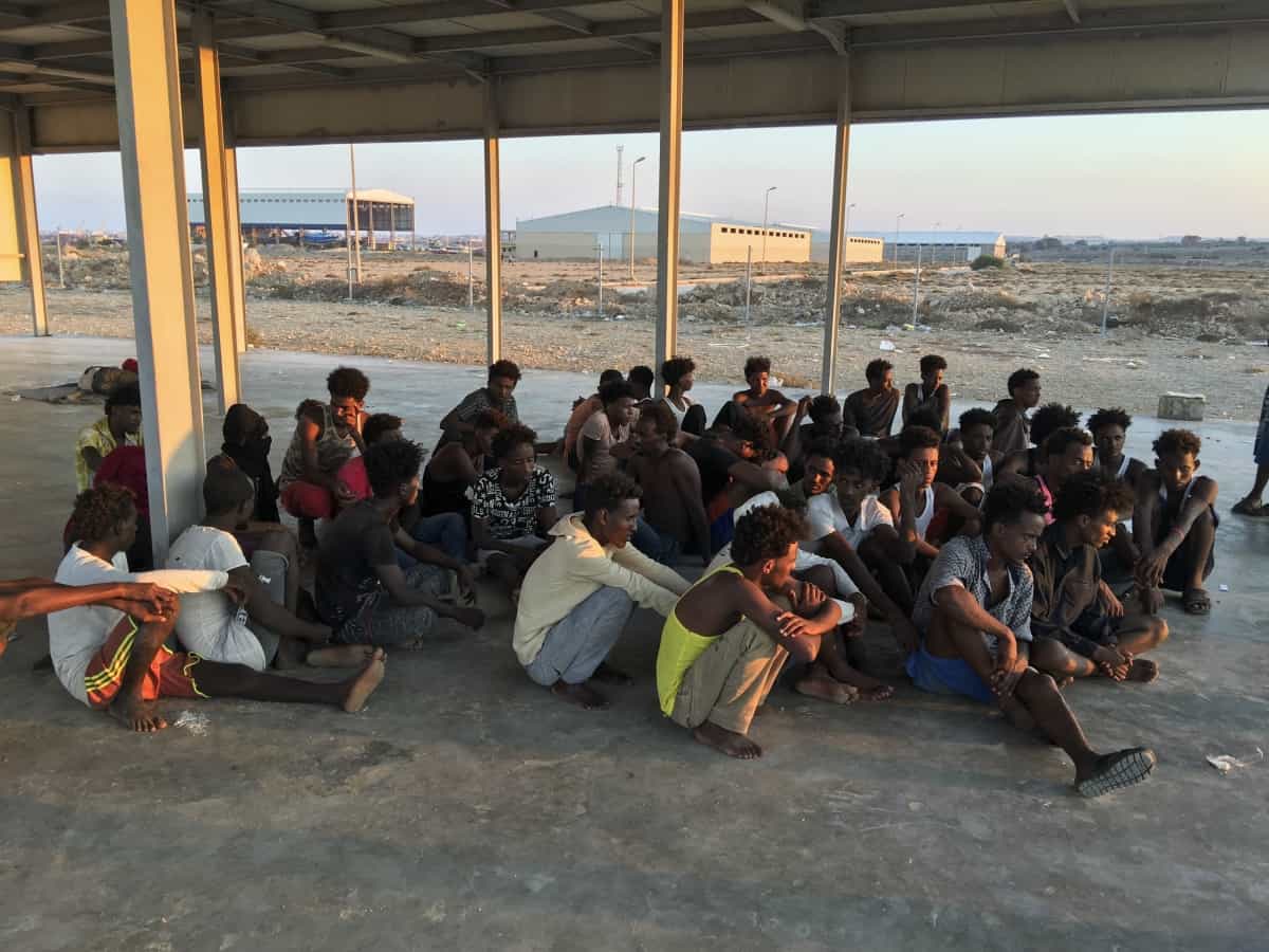 Rescued migrants sit on a coast (Hazem Ahmed/AP)