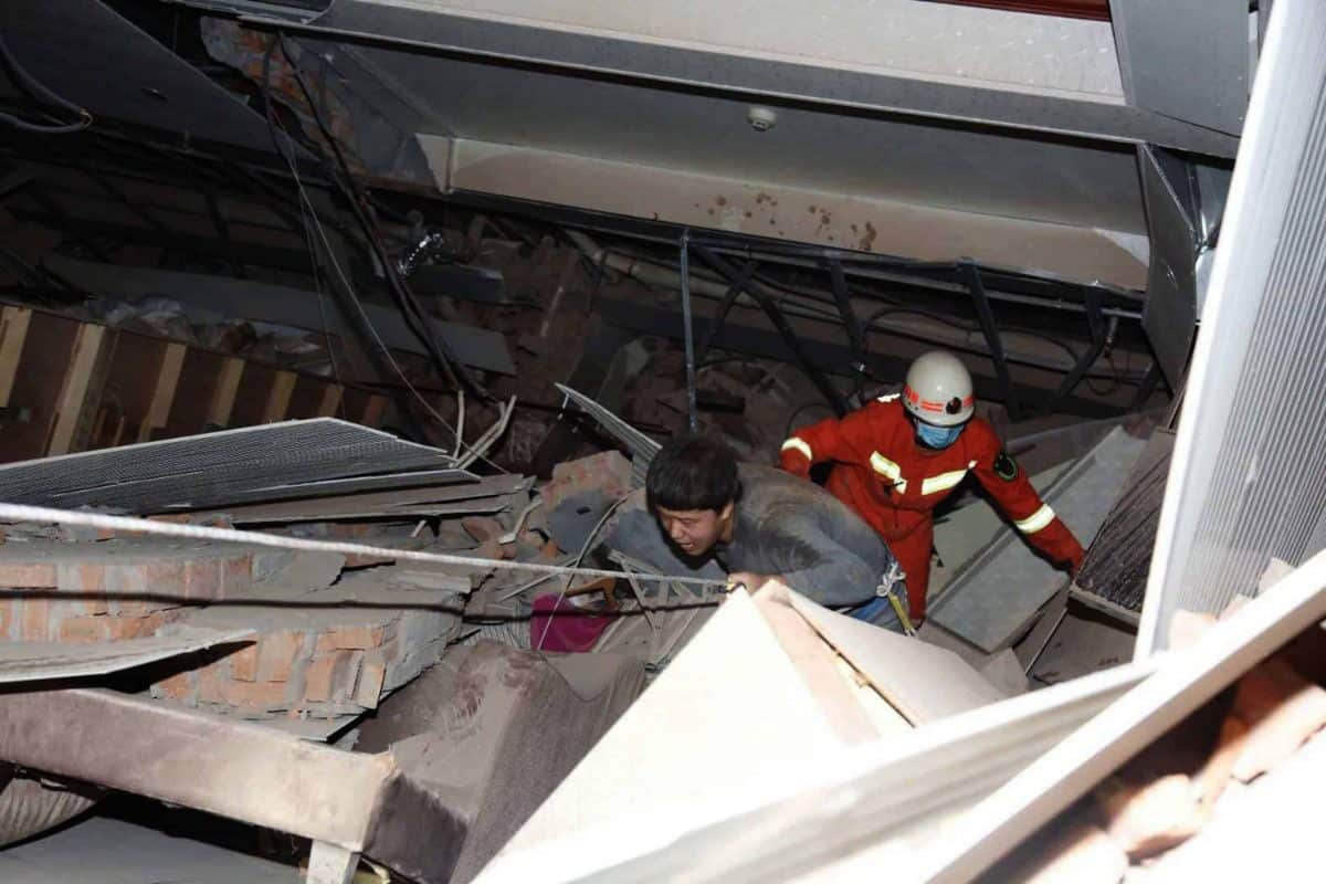 A man is assisted out from the rubble of a collapsed hotel building in Quanzhou city in southeast China's Fujian province Saturday, March 07, 2020. The hotel used for medical observation of people who had contact with coronavirus patients collapsed in southeastern China on Saturday, trapping dozens, state media reported. (Chinatopix via AP)