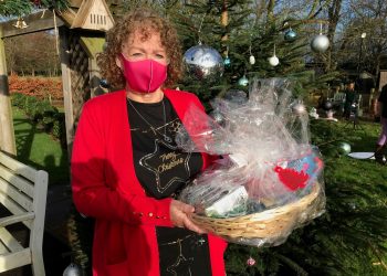 Carer Norma Kirby at Charnley Fold Day Centre in Bamber Bridge near Preston with a Christmas hamper delivered by Lottery winner Natalie Cunliffe. Credit;PA