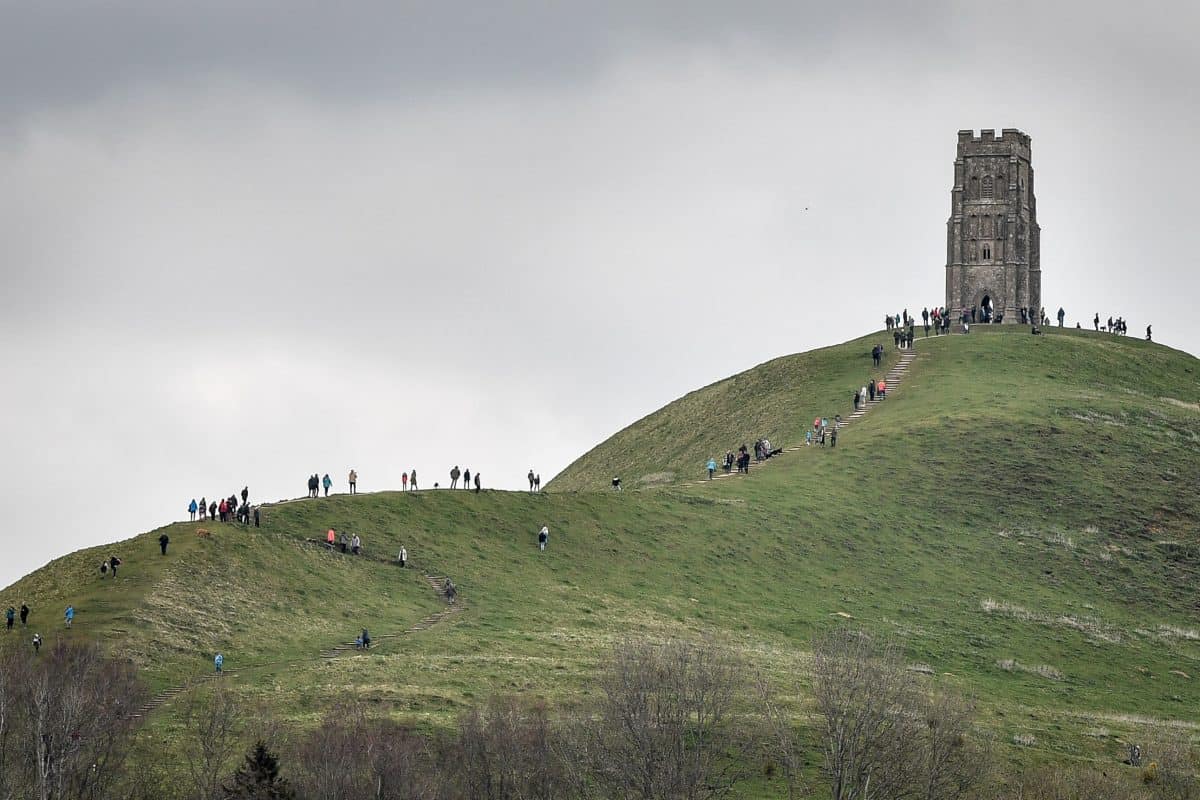 People walk up to St Michael's Tower on the top of Glastonbury Tor, Somerset, as forecasters have warned of treacherous driving conditions for Easter holidaymakers with snow and torrential rain on the way.